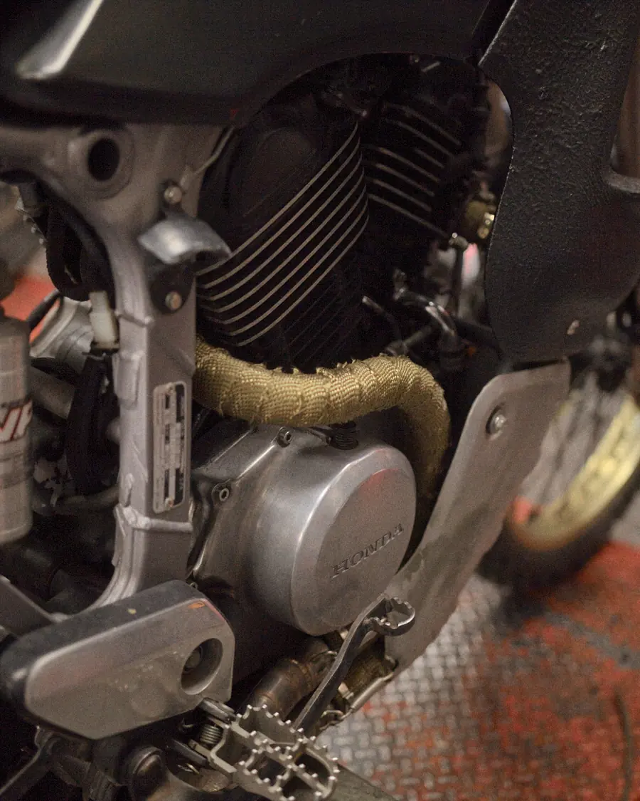 Il motore e l'ammortizzatore della moto nera di Bomber Garage