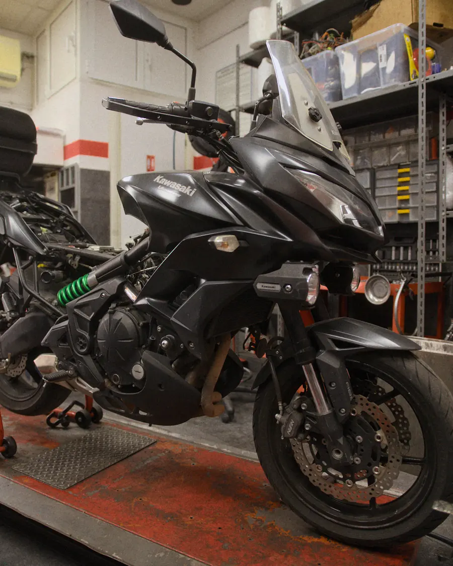 Una Kawasaki Versys nera sul cavalletto da officina